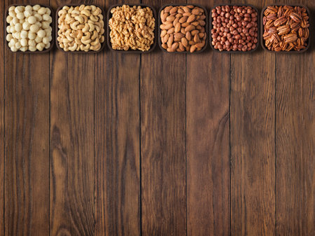 collection nuts and seeds on wooden table background with empty space.