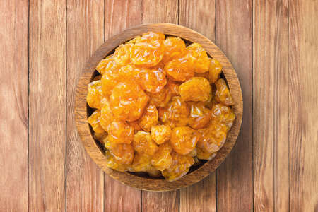 candied fruit, dried physalis with sugar in wooden bowl on background of table. healthy vegetable food.の写真素材