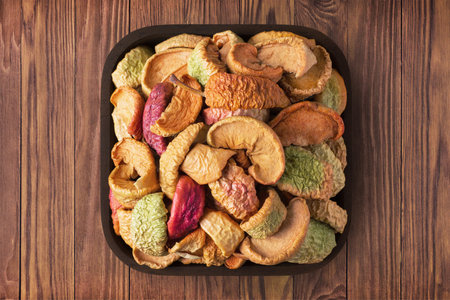 dried apples in square bowl on rustic table, top view.の写真素材