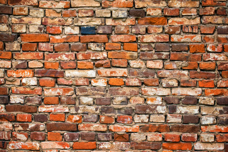 old brick wall made of crumbling cobblestones, brickwork as background