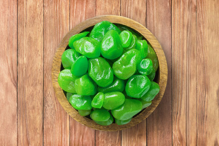 candied fruit, dried kumquat together sugar, with lime flavor in wooden bowl on background of table.の写真素材