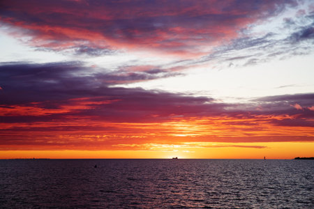 stunning sunset over the sea, colorful clouds absorb the sun's raysの写真素材