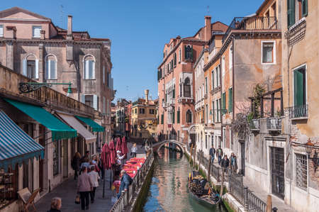 VENICE, ITALY - APRIL 13: Tourists on street Fondamenta Osmarin on April 13, 2013. Gondola on canal Rio di S.Provoio with bridge Ponte del Diavolo, Veneto, Venice, Italyのeditorial素材