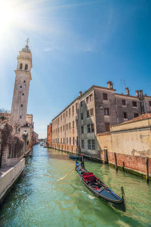 Gondolier on gondola in Rio del Greci near the campanile of church San Giorgio dei Greci, Venice, Italyのeditorial素材