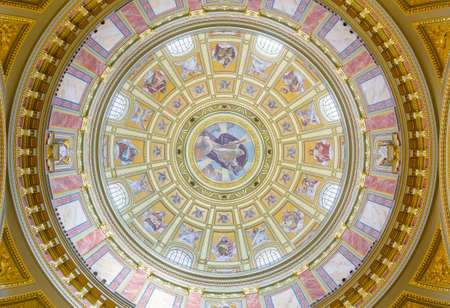 BUDAPEST, HUNGARY - FEBRUARY 22, 2016: Interior of the cupola. Roman catholic church St. Stephen's Basilica. Richly decorated ceiling with mural and gold details. Painted scenes from the Bible.のeditorial素材