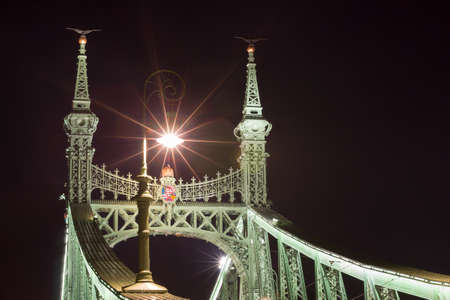 BUDAPEST, HUNGARY - FEBRUARY 22, 2016: Liberty Bridge or Freedom Bridge in Budapest, Hungary. Coat of arms and Turul birds on top of the pilar.のeditorial素材