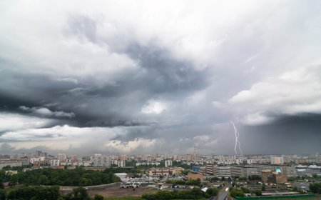 Lightning bolt over city in stormy day.