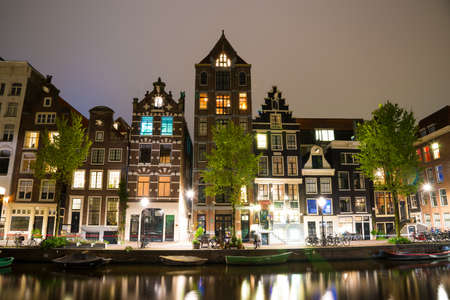 Amsterdam, Netherlands - April 20, 2017: Amsterdam canal Singel with typical dutch houses and houseboats by night, Holland, Netherlands.のeditorial素材