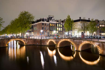 View of the Amsterdam canals and embankments along them at nightの写真素材