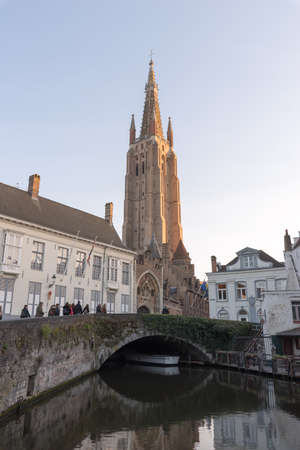 Bruges, Belgium - April 15, 2017: The tower of Church of Our Lady and canal in Brugge, Belgium.のeditorial素材