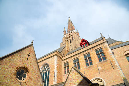 Bruges, Belgium - April 18, 2017: Old buildngs and the tower of Church of Our Lady in Brugge, Belgium.のeditorial素材