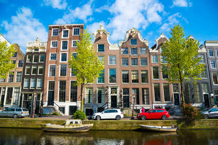 Amsterdam, Netherlands - April 19, 2017: Colorful houses and cars along the canal embankment in Amsterdam, Netherlandsのeditorial素材