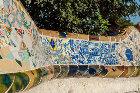 Barcelona, Spain - September 20, 2014: Large undulating seating area in the centre of Guell Park, Barcelona. The ceramic tiles that adorn the seating area are full of colours and interesting designs.のeditorial素材
