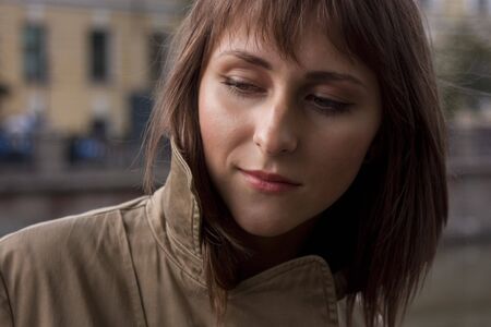 Portrait of young beautiful woman in raincoatの写真素材