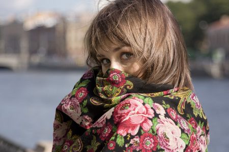 Portrait of young beautiful woman hiding in shawlの写真素材