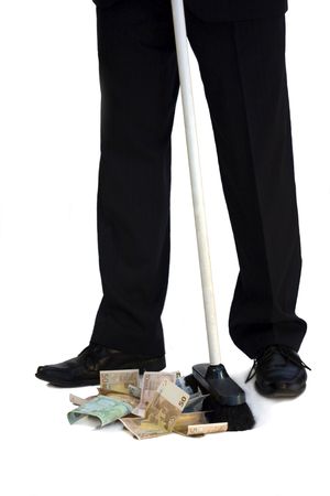 a man in business suit sweeps money with mopの写真素材