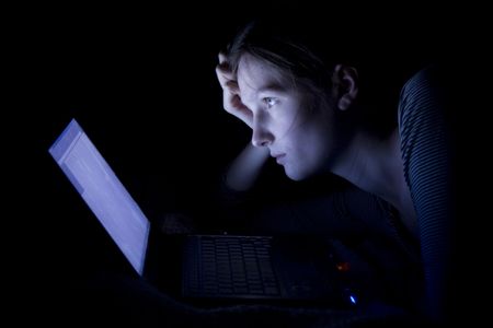 Young woman with laptop at nightの写真素材