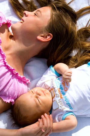 little girl and her baby brother lying side by side