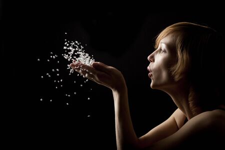 beautiful woman blowing white fluffの写真素材