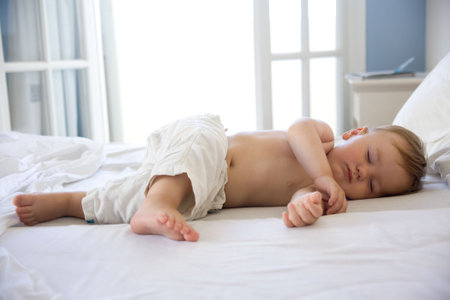 cute baby boy sleeping on bed