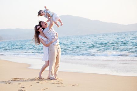 happy young family having fun on the beachの写真素材