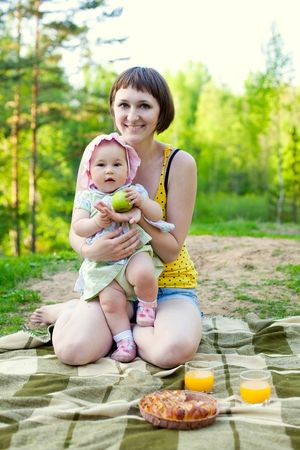 happy mother with cute baby daughter having picnic in the natureの写真素材