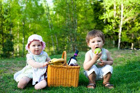 baby girl and little boy having picnic in the natureの写真素材