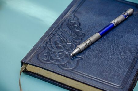 Exquisite blue leather notebook on a turquoise background. Close-up. Selective focus.の写真素材