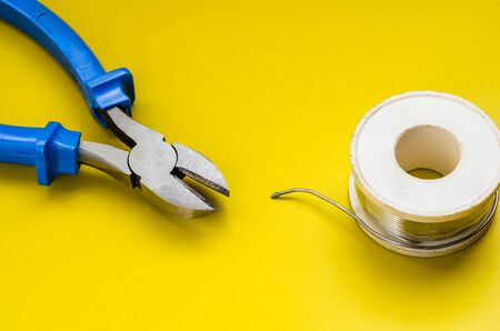 Nippers with blue handles a solder coil. Jack of all trades or industry.の写真素材