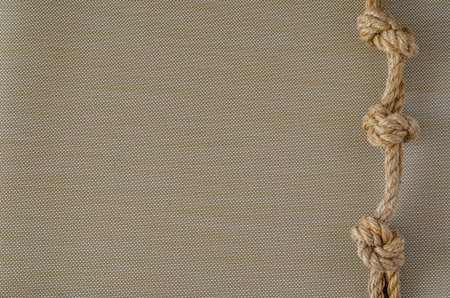 Hemp rope with three knots. Abstract background with natural ropes. Sailing or fishing. View from...