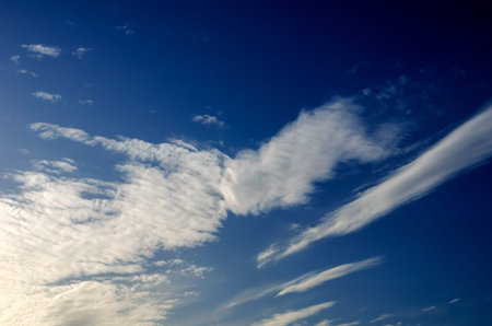 White cirrus clouds in the blue sky. Beautiful sky with spring clouds in the sun. Natural...