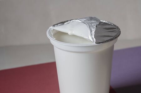 Full plastic cup of fermented milk product. Healthy eating Side view. Eye level shooting. Selective focus.の写真素材