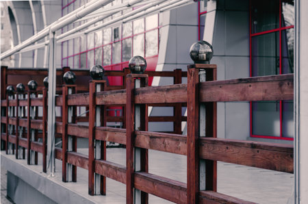 Terrace of an empty summer cafe. Decorative wooden railing with round lights. The concept of tourism, travel, vacation. Side view. Selective focus. Without people. City life.の写真素材