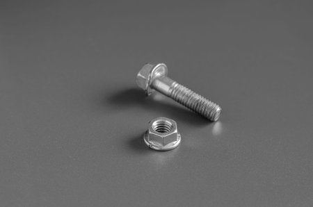 Bolt and nut on a gray background.  Close-up nut with skirt and used bolt. Eye level shooting....