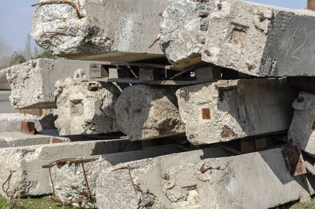 A pile of old concrete piles outdoors. Used reinforced concrete products stacked on top of each other. Reuse of building materials. Selective focus. Without people.の写真素材