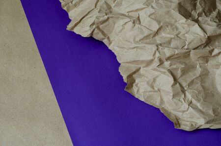 Brown and lilac paper. Two-color abstract background with a piece of crumpled paper. Multi-tasking framework for various design tasks. Selective focus.の写真素材
