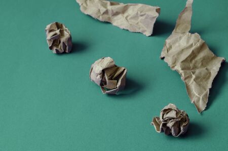 Crumpled and torn pieces of paper on a light turquoise background. Three balls of paper and two crumpled paper pieces. The basis for a variety of design tasks. Close-up. Selective focus.の写真素材