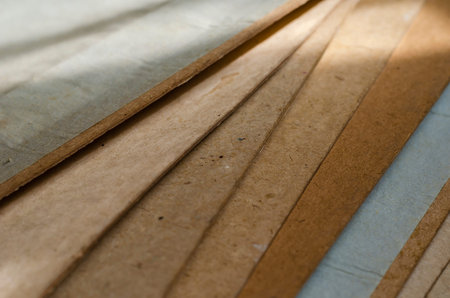 Sheets of old cardboard in the sun. Sheets of dusty construction cardboard stack closeup. Building...