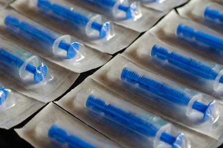Medical syringes in packaging as an abstract background. Blue Medical syringes in a package. Selective focus. Close-up.の写真素材