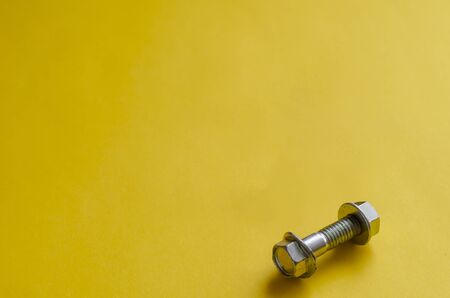 Bolt with nut close-up. One bolt and nut with washer. Industrial themes and minimalism. Selective focus. Top view at an angle.の写真素材