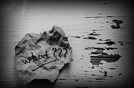 Crumpled paper with the question what. Question written by hand on a piece of torn paper. A scrap of...