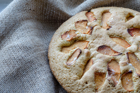 Tasty pie with quince slices. Homemade Sweet quince pie. Traditional round pie on burlap. Baking...