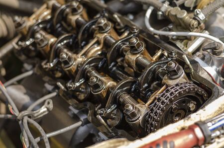 Disassembled four-stroke gasoline engine. Detailed shot of carburetor engine without valve cover. Retro car repair. Side view. Selective focus. Close-up.の写真素材
