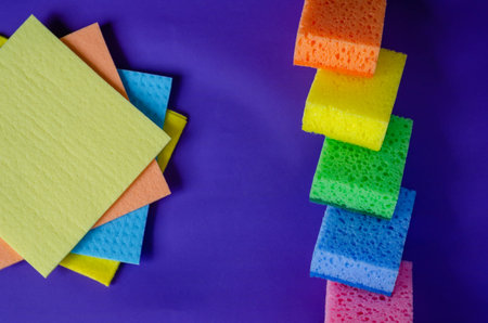 Kitchen napkins and sponges on a blue background. Set of multi-colored napkins and kitchen sponges....