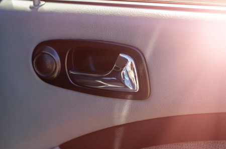 Internal car door handle with speaker. Close-up of a chrome door handle. The interior of the car....
