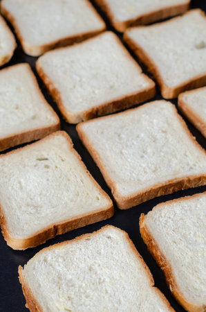 Sandwich bread background. Pieces of bread laid out in a line. Focus in the foreground. Angled side...