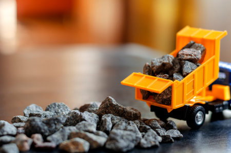 Plastic toy for children dump truck. Orange dump truck pours gravel out of the body. Toys for kids....