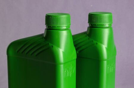 Green Plastic cans with motor oil. Plastic containers for automotive lubricants. Car service. Automotive chemistry. Selective focus.の写真素材