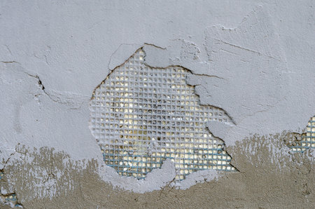 Exterior wall of a building with damaged stucco. Demonstration of poor-quality insulation of...
