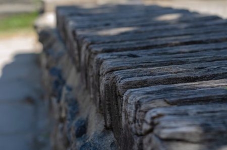 Old Cracked Wooden Bars Closeup. Texture of dry weathered wood outdoors. Selective focus.